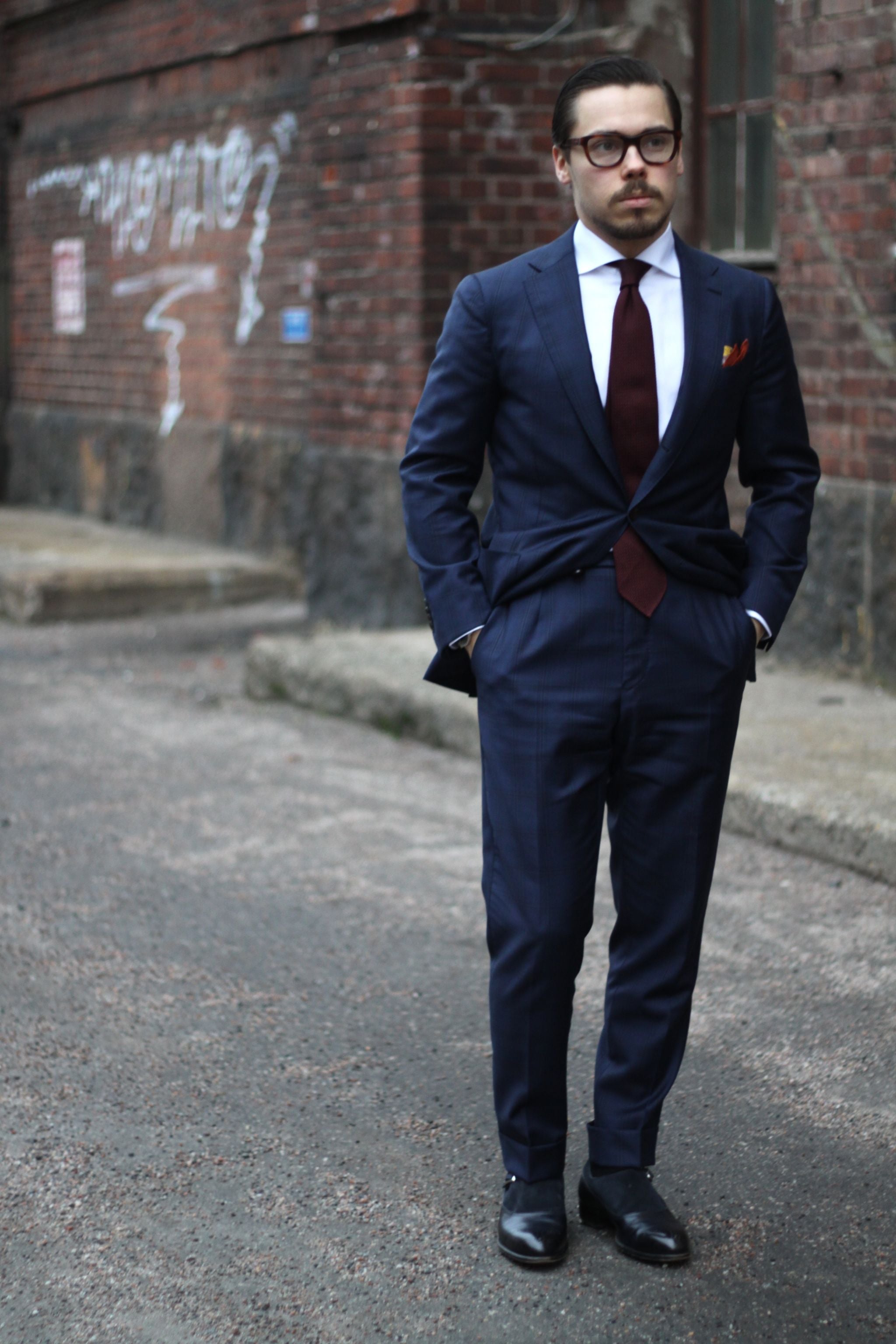 Dark blue suit with white shirt and burgundy tie is classic business attire.