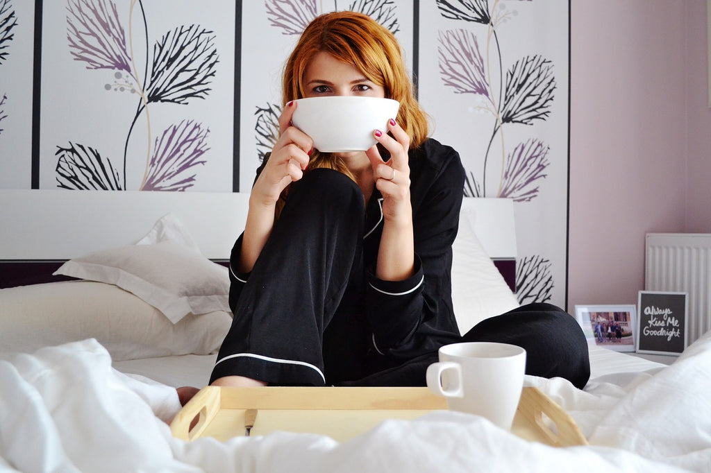 Woman in bed enjoying a low-carb breakfast