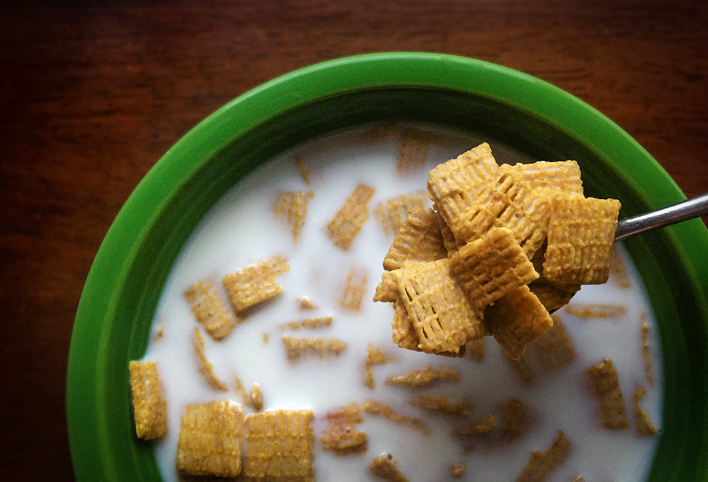 Green bowl of cereal with milk