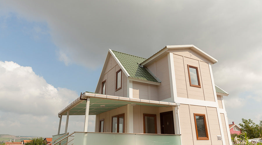 yeşil çatısı olan iki katlı, geniş prefabrik ev