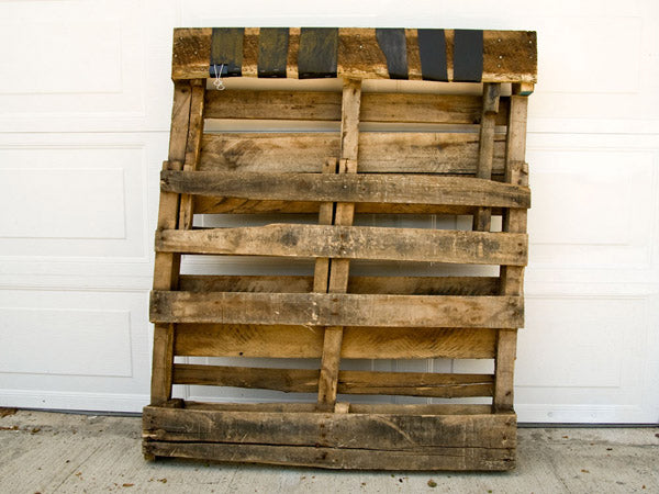 a wooden pallet leaning against a garage door