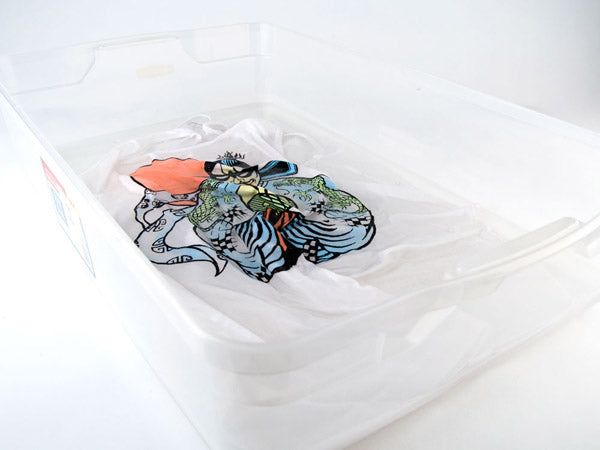 screen-printed shirt soaking in a clear plastic tub