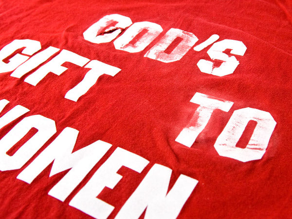 a red t-shirt with white lettering that has been scratched with sandpaper