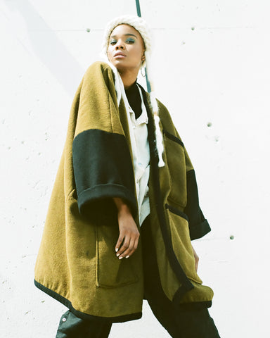 Female model wearing an upcycled military blanket coat by Neoteny Apparel