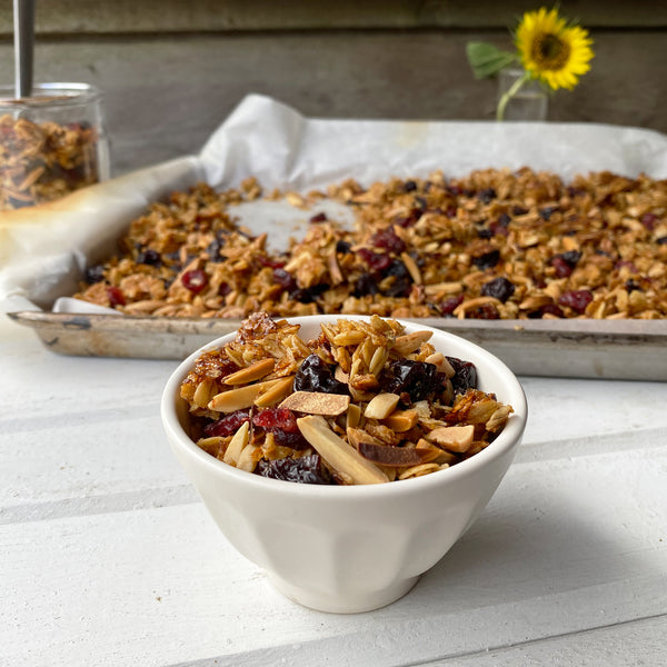 a small bowl of cherry-almond granola on a rustic tabletop