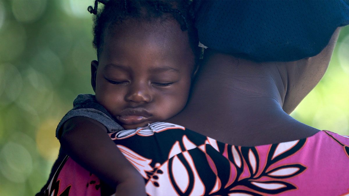 Girl sleeping on mother's shoulder