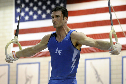 man on wooden gymnastic rings