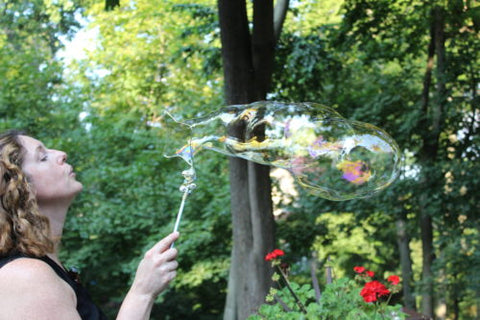 Woman blowing bubbles with DIY bubble wand