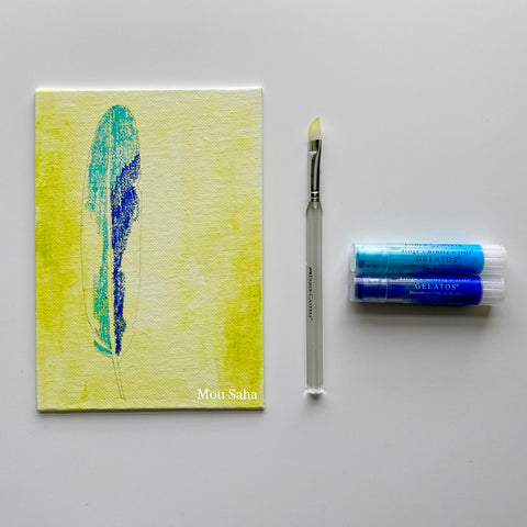 Canvas with a painted feather, a paintbrush, and two Gelatos