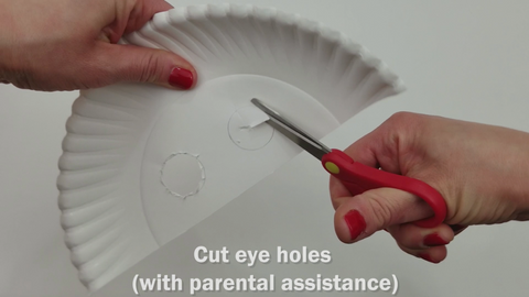 Scissors cutting holes in paper plate