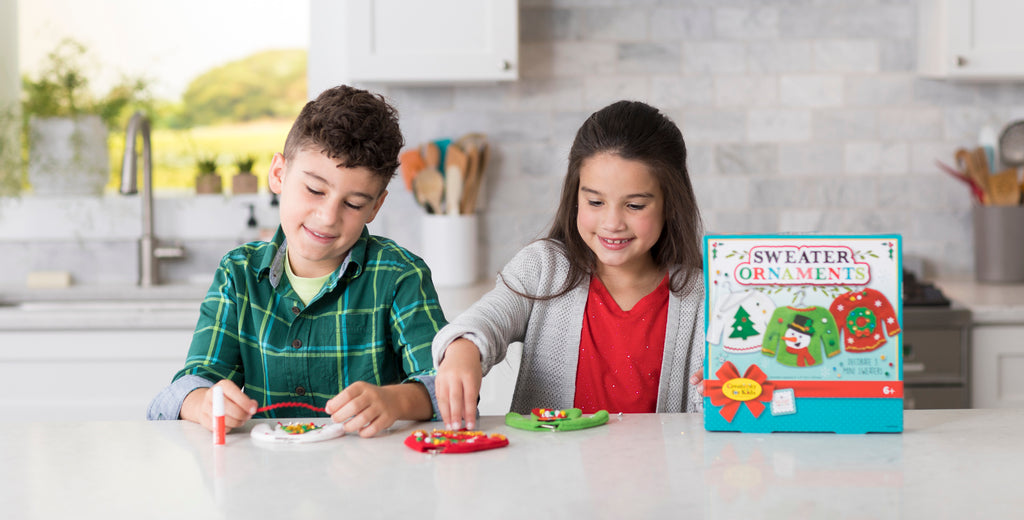 Boy and Girl crafting Christmas sweater ornaments