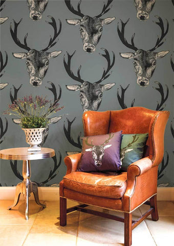 Stag print wallpaper shown with a traditional style tan leather chair.