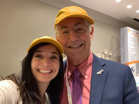 Emily Sauer and Irwin Goldstein wearing matching "Pain is Not a Weakness" hats. 