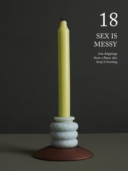 Image of an Ohnut around a green candlestick. "18. Sex is messy—wax drippings from the flame also keep it burning."