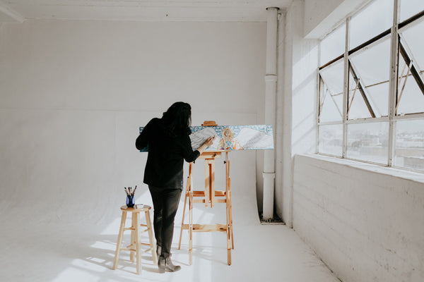 Artist Vivian at work in her studio standing at easel