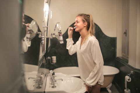 Woman brushing her teeth; image courtesy of Pexels.com