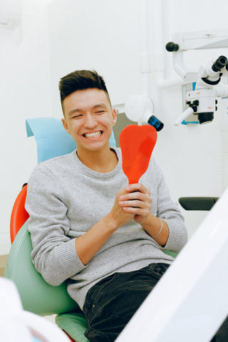 Dental patient smiling; photo courtesy of Unsplash