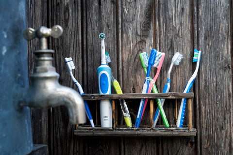 Toothbrushes on a rack; image courtesy of Pixabay