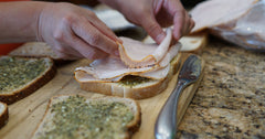 Placing turkey meat on a piece of bread