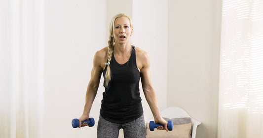 Sunny trainer doing dumbbell workout