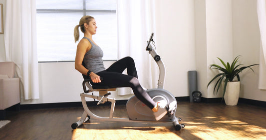 a woman is pedaling a recumbent bike