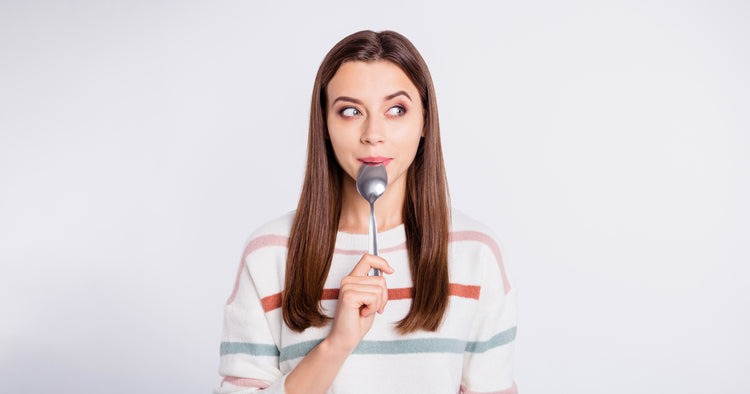 A hungry lady holding spoon into mouth dream of tasty meal