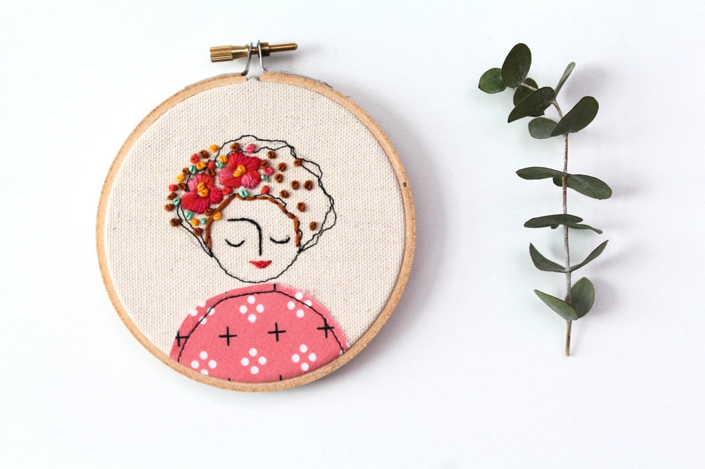 Embroidery of a woman in pink with camellias in her hair