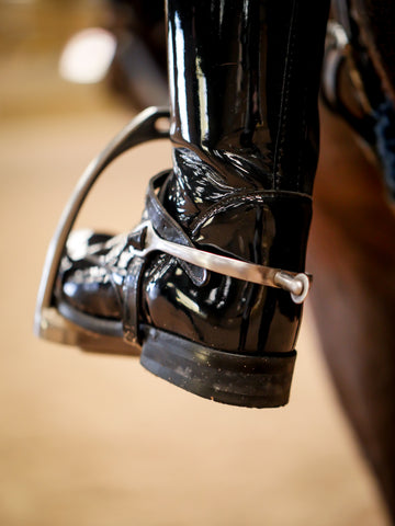 A close up of a riding boot in a stirrup