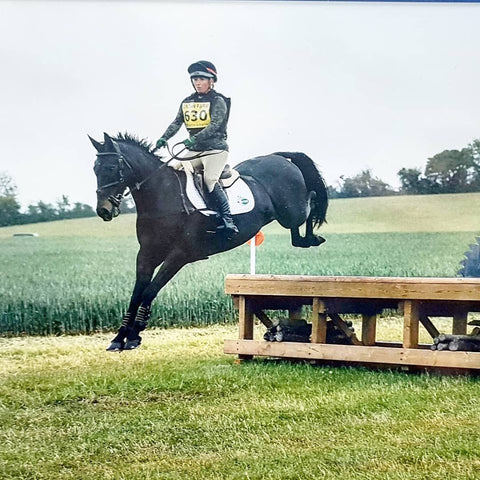 A horse finishing clearing a small jump