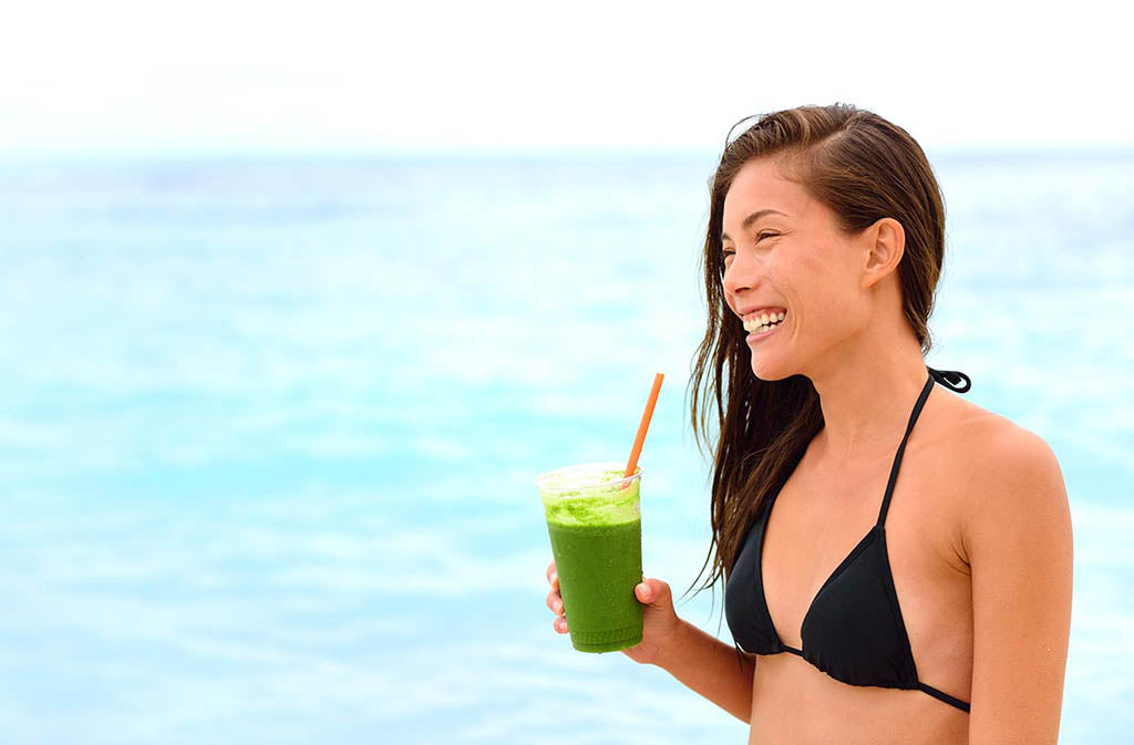 woman in bikini holding marine collagen smoothie