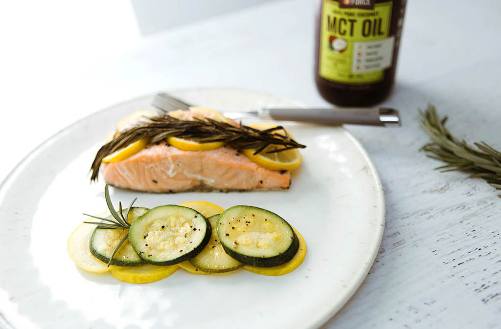 white plate with baked salmon and slices of zucchini and summer squash