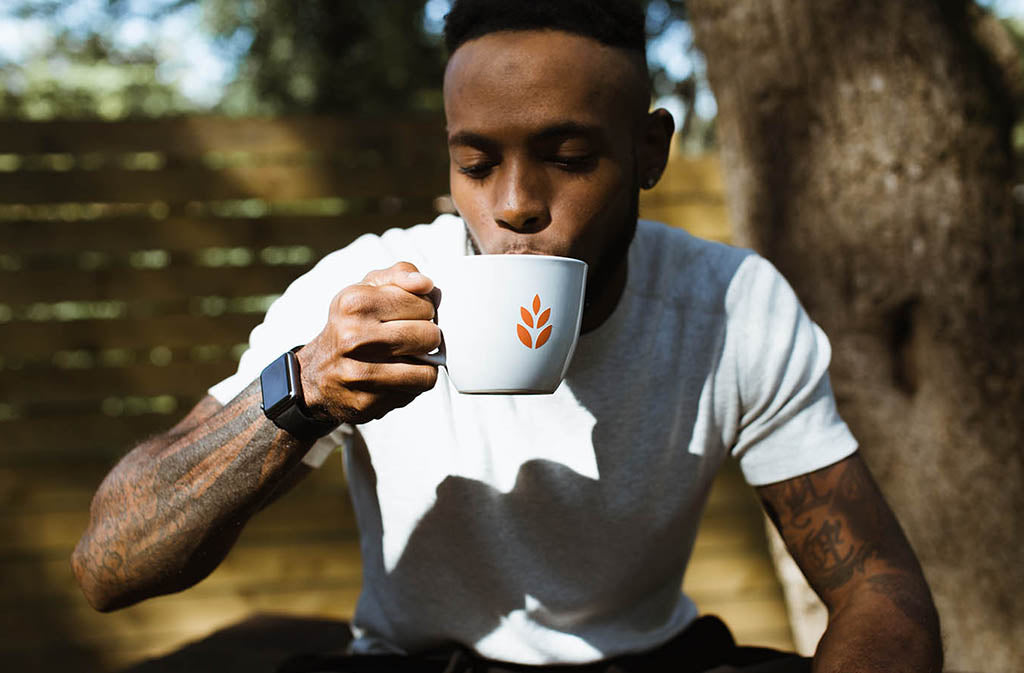 fit man sipping a mug with the natural force leaf logo