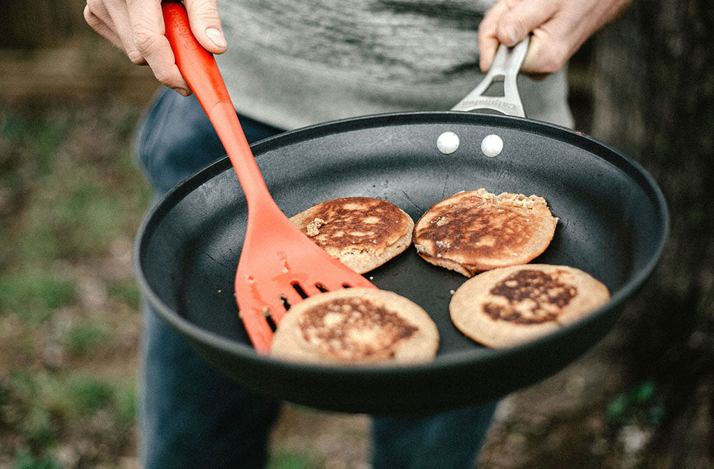 man holding pan with paleo protein pancakes