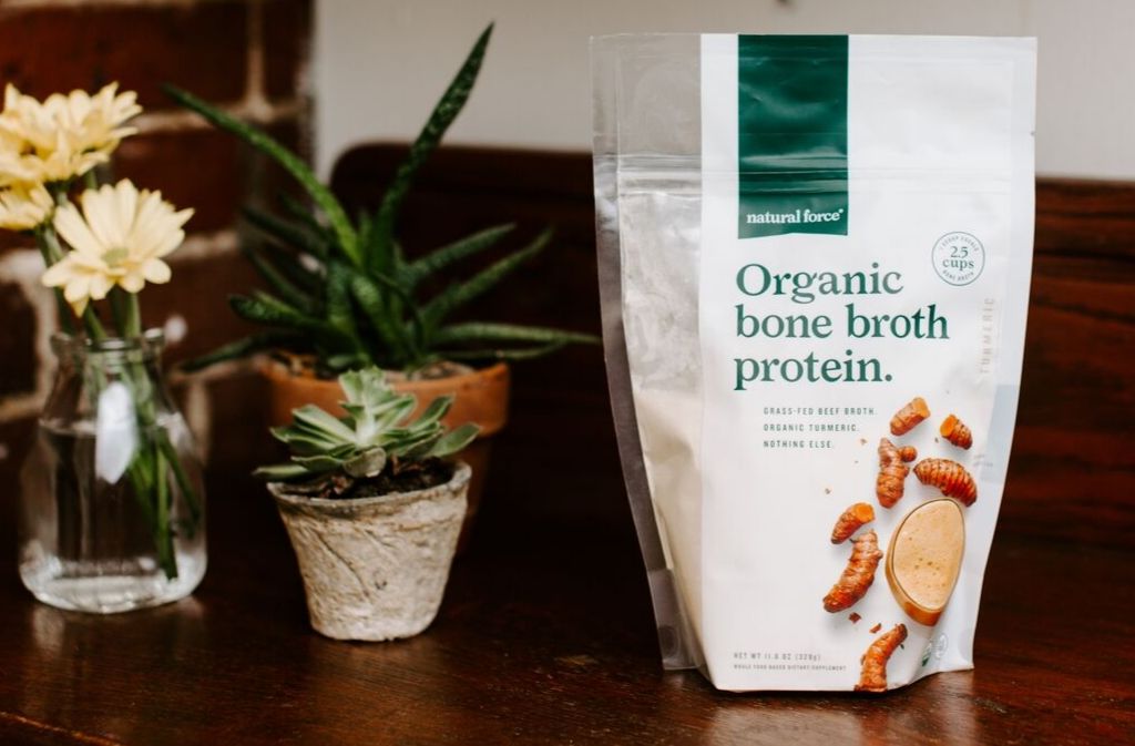 bag of natural force organic turmeric bone broth protein on a counter next to succulents