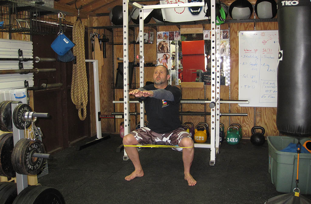 man doing a banded squat