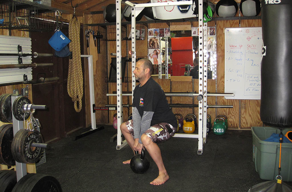 man in position for sumo deadlift squat