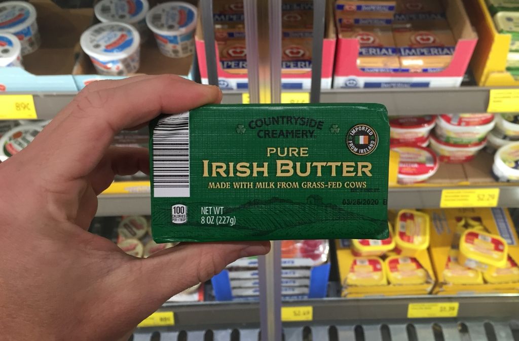 hand holding a package of irish butter