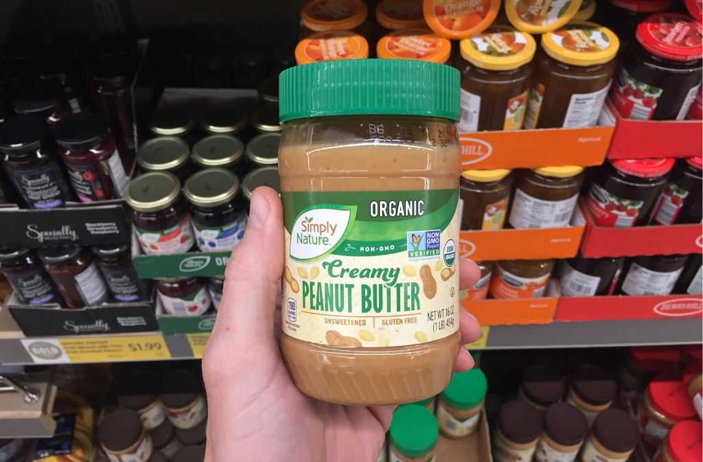 hand holding a jar of peanut butter