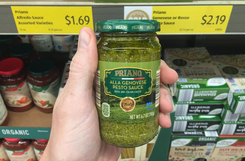 hand holding a jar of pesto