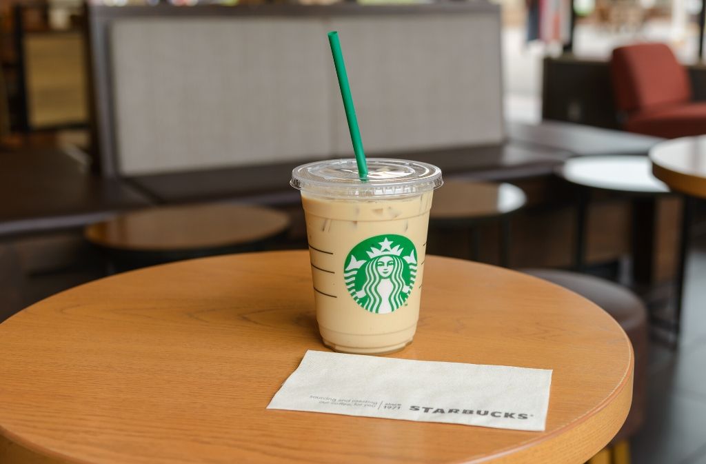 keto friendly iced Starbucks coffee on a round cafe table beside a starbucks paper napkin