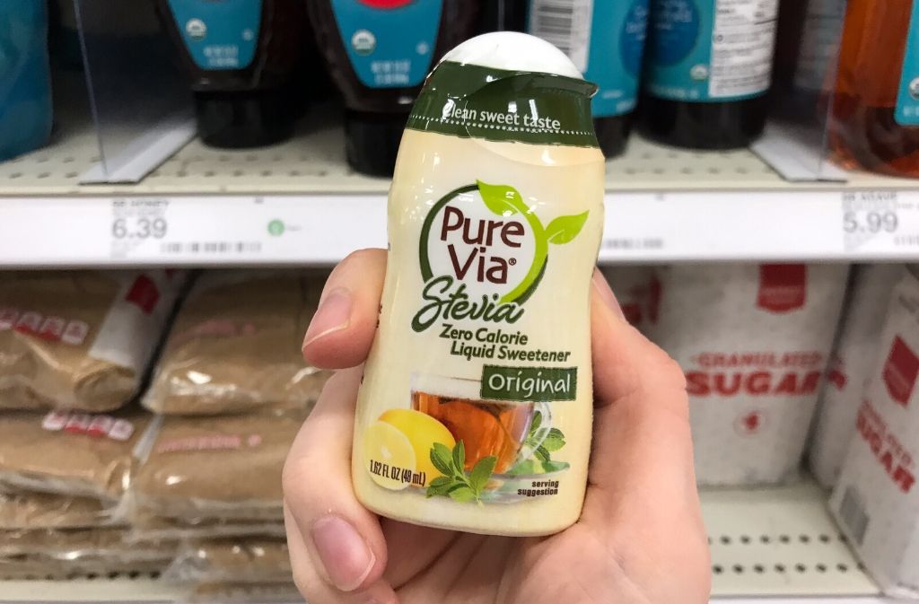 hand holding a small container of pure via liquid stevia