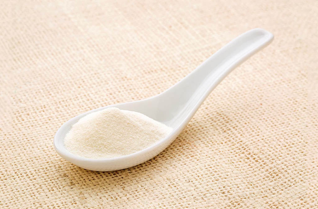 spoonful of mct powder on a linen surface