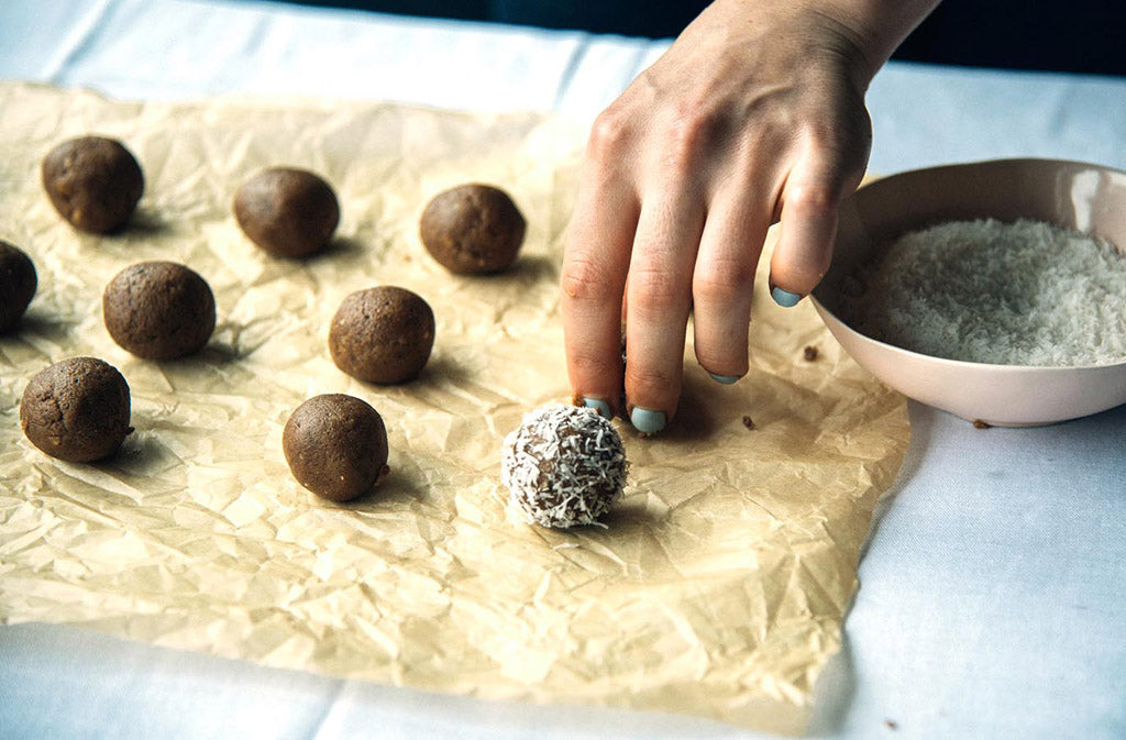 hand setting mint chocolate keto energy balls on a piece of parchment paper