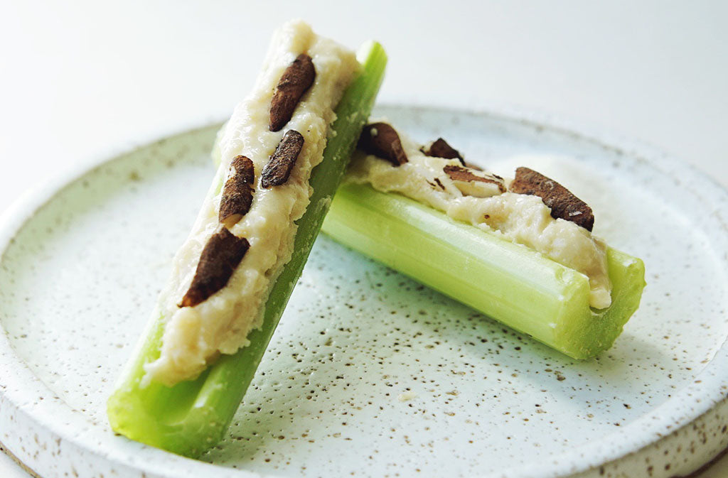 raw cacao keto ants on a log on a white plate