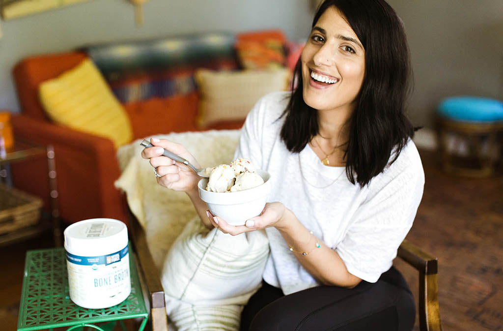 woman smiling holding up a bowl of dairy free cake batter nice cream