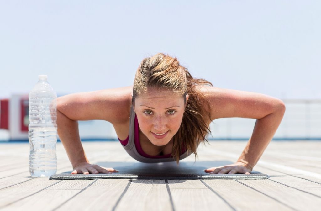 a woman at the bottom of a push up looking at the camera and smiling