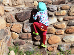 Toddler climbing a wall.