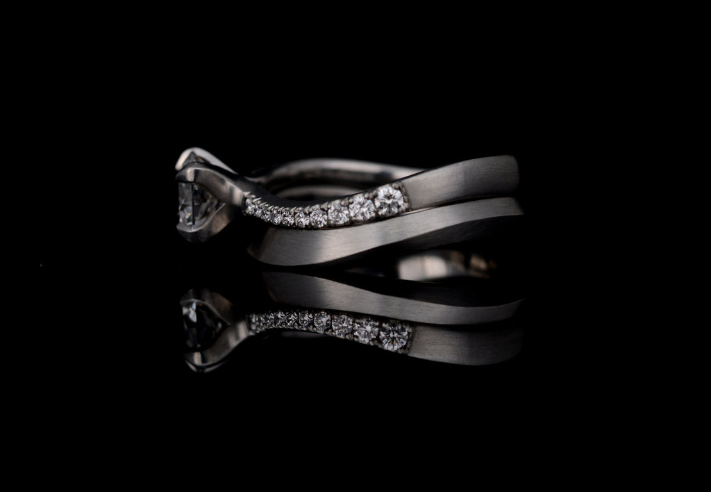 Platinum bespoke s-curve engagement ring with matching wedding band.