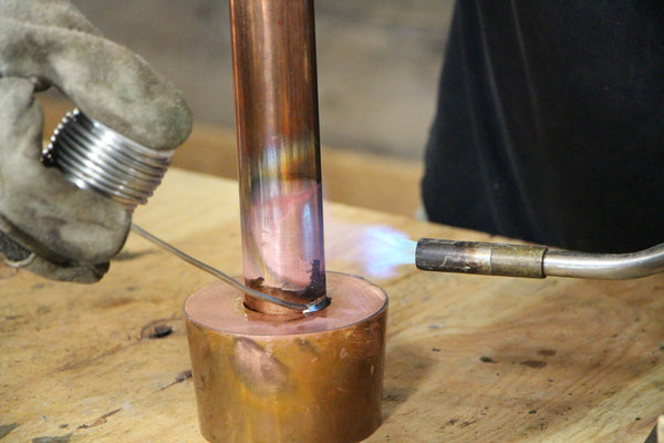 Solder column into cap plate opening