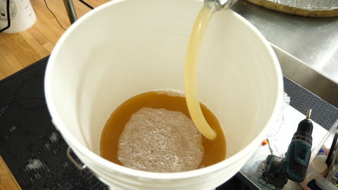 transferring beer from a kettle into a fermentation bucket